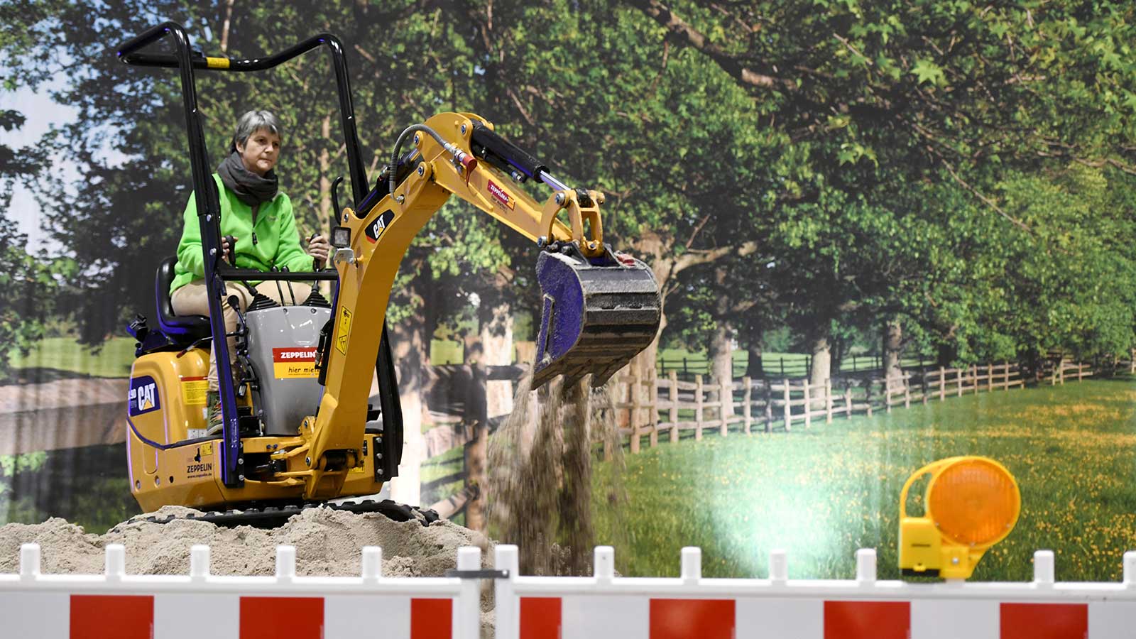 A female visitor on an excavator at the Messer home2 trade show in the Hamburg exhibition halls
