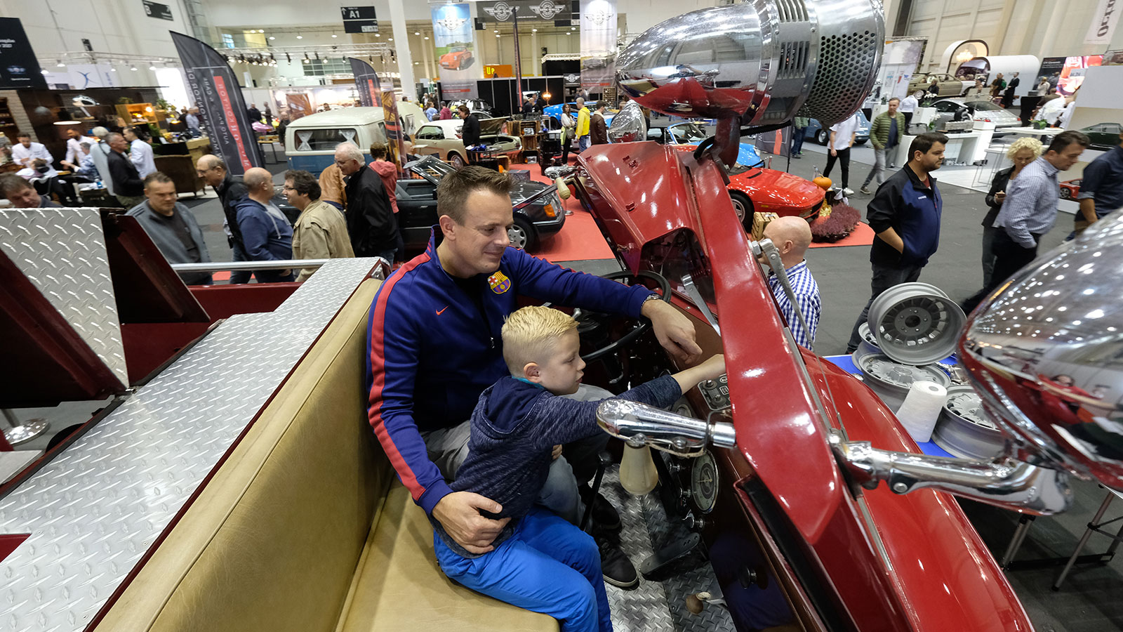 Hamburg Motor Classics: a child and an adult visitor in a classic car